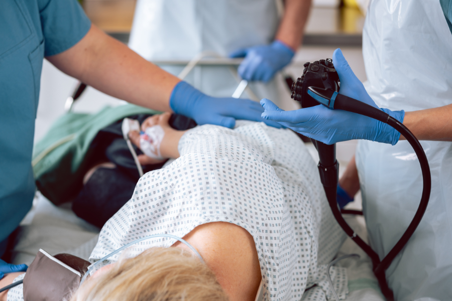 Clinicians performing an endoscopic examination on a patient.