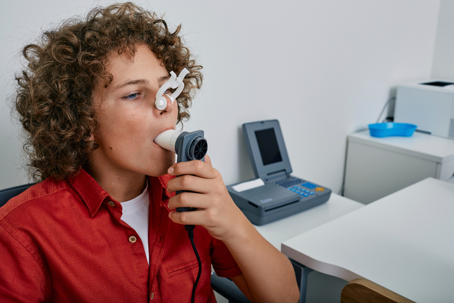 Person using a handheld breathing device.
