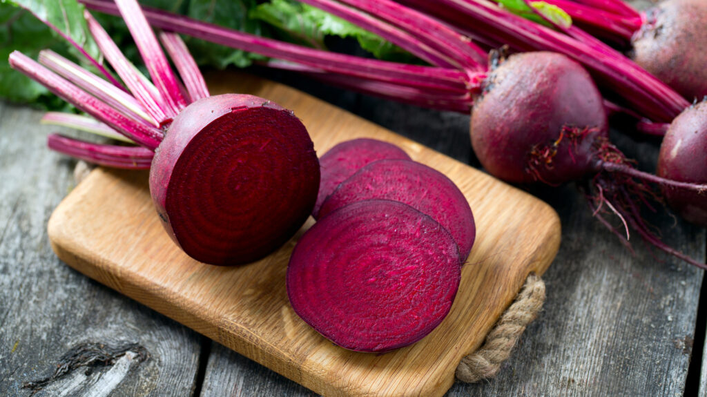 Whole and sliced beets on a board.
