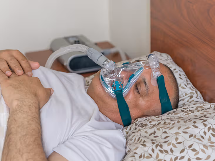 Person sleeping while using a CPAP mask.